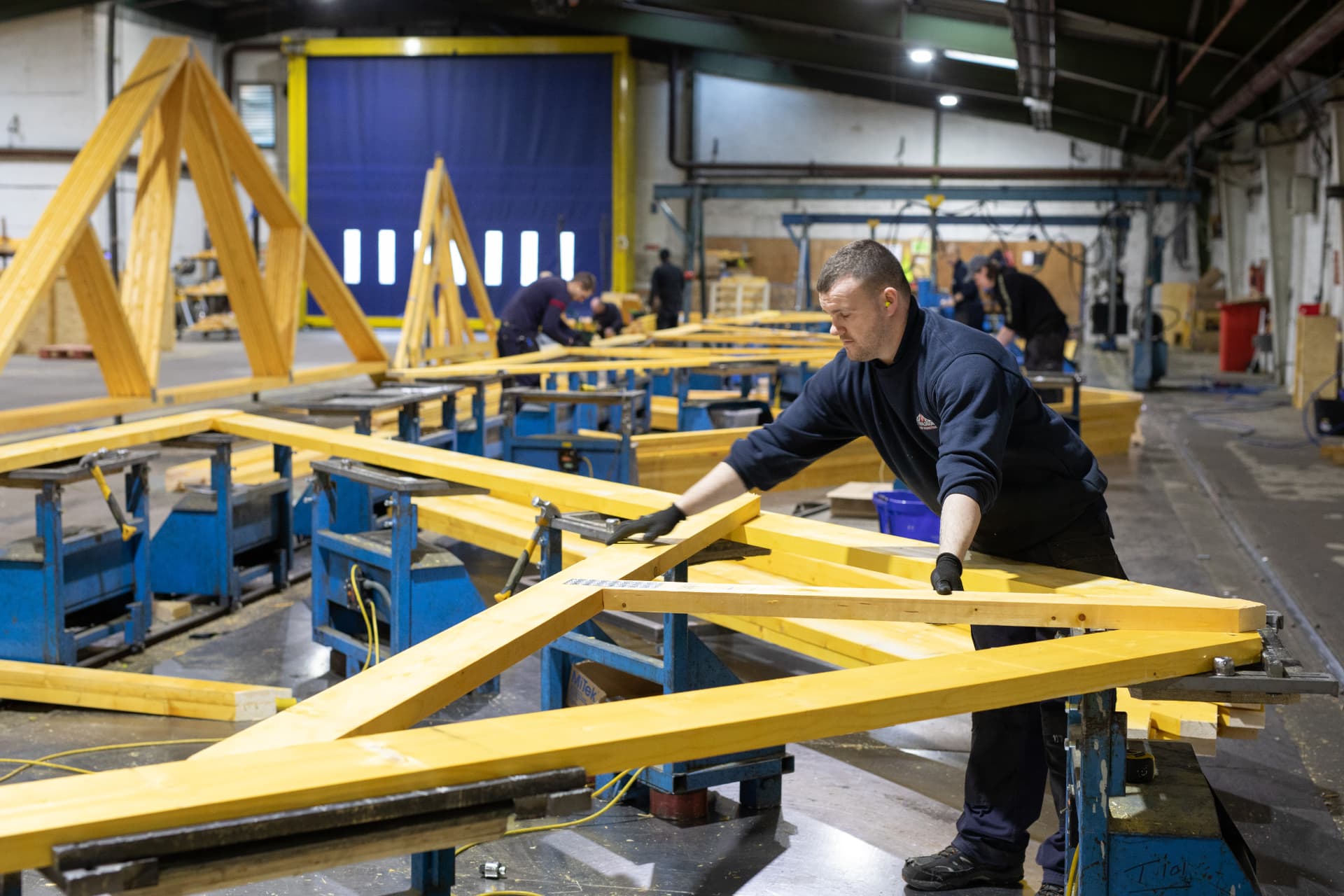 DTE joiner positioning truss timbers on the pressing bench